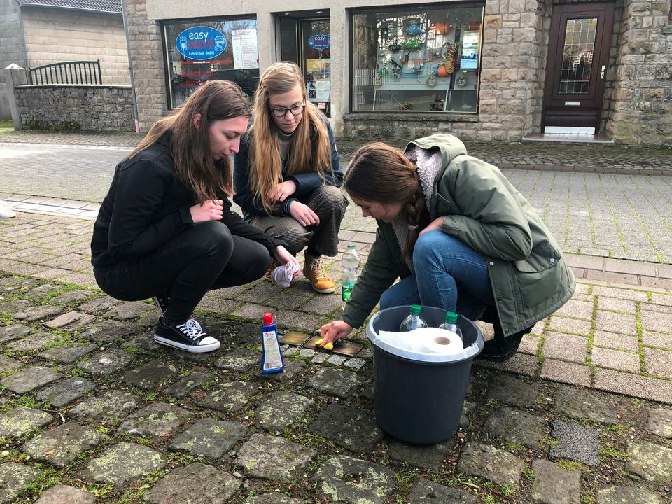 Die drei Stolpersteine für Familie Kaufmann gesäubert, mit Kerzen und Rosen geschmückt haben die Abiturienten des St. Michael-Gymnasiums und damit ein sichtbares, mahnendes Zeichen gesetzt. Foto: T. Förster