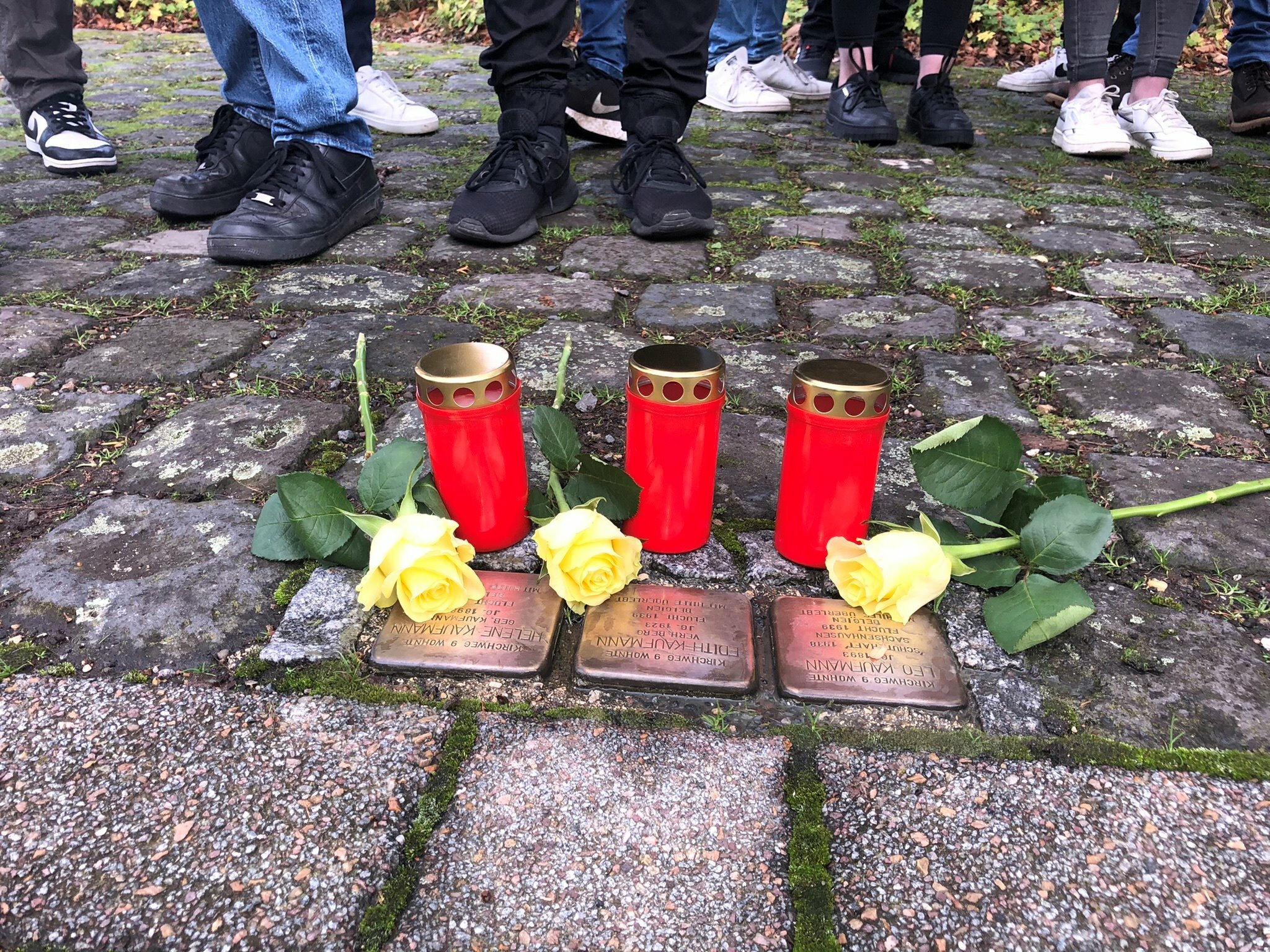Die drei Stolpersteine für Familie Kaufmann gesäubert, mit Kerzen und Rosen geschmückt haben die Abiturienten des St. Michael-Gymnasiums und damit ein sichtbares, mahnendes Zeichen gesetzt. Foto: T. Förster