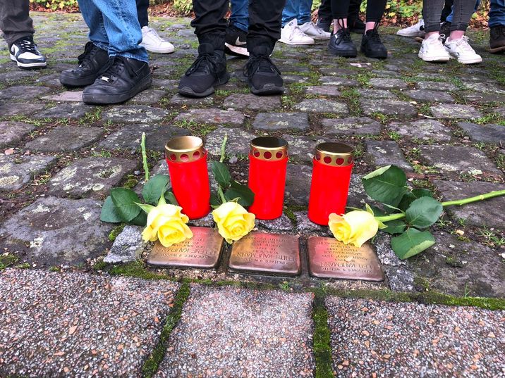 Die drei Stolpersteine für Familie Kaufmann gesäubert, mit Kerzen und Rosen geschmückt haben die Abiturienten des St. Michael-Gymnasiums und damit ein sichtbares, mahnendes Zeichen gesetzt. Foto: T. Förster