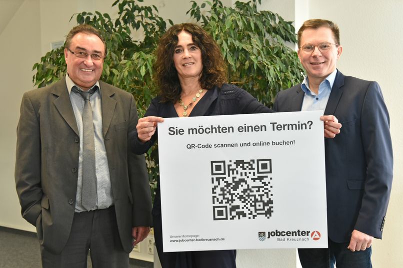 Bruno Eckes (l.), Patricia Reidenbach und Hans-Jörg Schnadthorst freuen sich, dass die Kunden des Jobcenters in Bad Kreuznach und Kirn ab sofort erweiterte Öffnungszeiten und einen QR-Code zur Terminvereinbarung nutzen können.